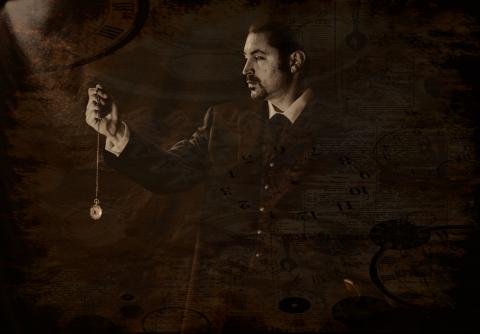 a black and white photo of Keith Zalinger's profile, he is holding a pocket watch