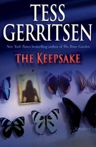 The book cover for The Keepsake, several butterflies are pinned to paper, in between them is a picture of a person