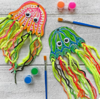 Jellyfish made from painted cardboard, googly eyes and yarn.